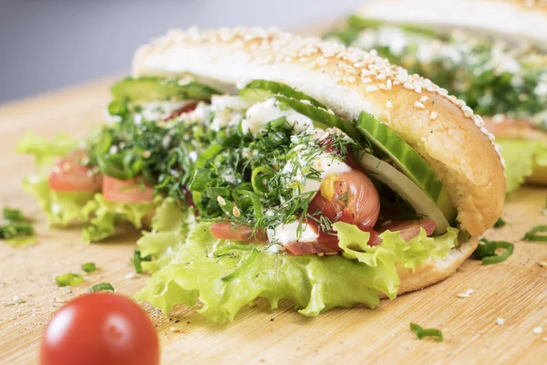 hızlı abur cubur lezzetli sosisli sandviç küçük kiraz domates yakın masada sulu yeşil ve Barbekü soslu