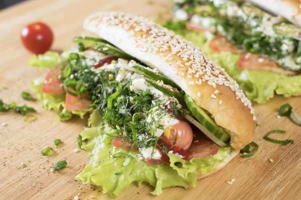 hızlı abur cubur lezzetli sosisli sandviç küçük kiraz domates yakın masada sulu yeşil ve Barbekü soslu