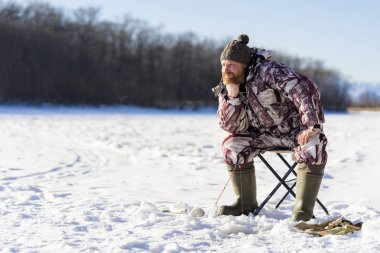 Sakallı Avrupa üzgün adam o kış balıkçılık Nehri üzerinde buz delikten başarısız varmak süre sıkıcıdır