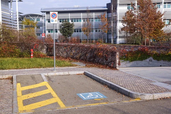 Signo minusválido marca plaza de aparcamiento, permiso de estacionamiento para discapacitados signo en poste con tienda de conveniencia en el fondo de la estación de servicio, espacio para copiar —  Fotos de Stock