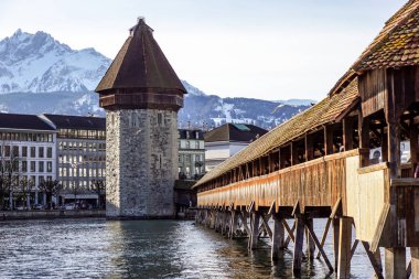 Lucerne, İsviçre - 2 Aralık 2017: Şapel Köprüsü ve su kulesi, Lucerne. Reuss Nehri ile ahşap kaplı köprü açıklıklı Mt. arka planda yükselen Pilauts ile.
