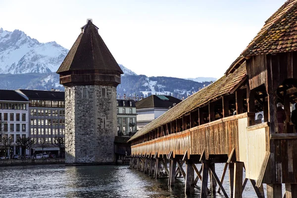 Lucerne, İsviçre - 2 Aralık 2017: Şapel Köprüsü ve su kulesi, Lucerne. Reuss Nehri ile ahşap kaplı köprü açıklıklı Mt. arka planda yükselen Pilauts ile.