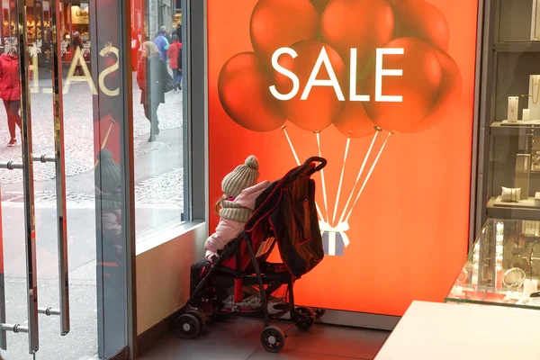 Londra, İngiltere'de 18 Aralık 2018: küçük kız onun sembolik ilgisizlik bir dükkanda Park ederken gösteren satış sırasında pencereden görünüyor. Satılık alışveriş arka plan