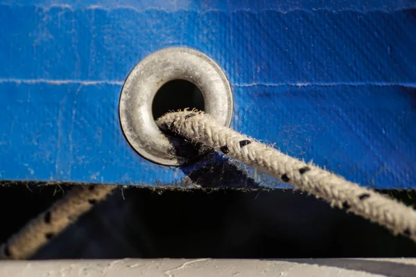Régi rozsdás fűzőlyukak egy éves kék bevont műanyag vászon — Stock Fotó