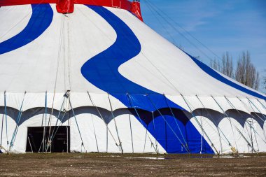 Yeşil doğanın bir mavi çizgili sirk çadırının.