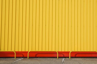 sarı metal paneli inşaat, mavi gökyüzü ile binanın duvarına.