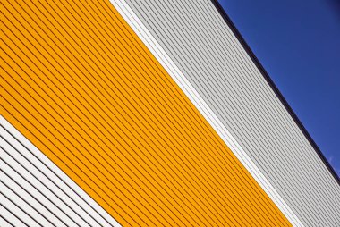 turuncu ve beyaz metal paneli inşaat, mavi gökyüzü ile binanın duvarına