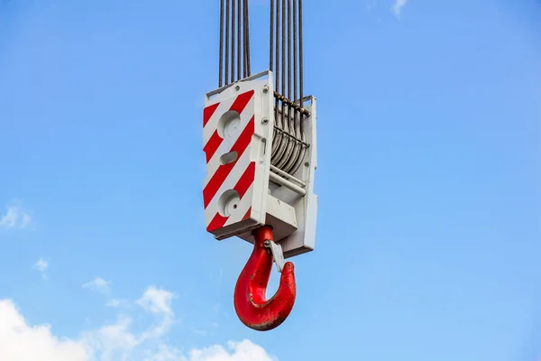 Crochet de grue avec rayures rouges et blanches suspendues, ciel bleu en arrière-plan — Photo