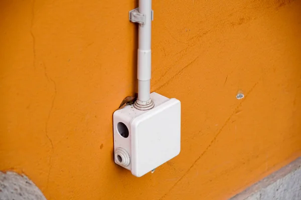 Scatola elettrica per la giunzione fuori porta, su parete gialla — Foto Stock