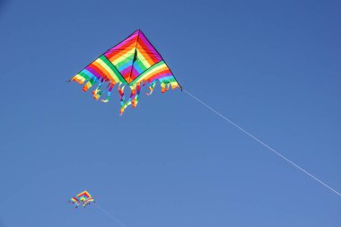 büyük renkli uçurtma yüksek gökyüzünde uçar. Güzel uçurtma Uçurtma Festivali