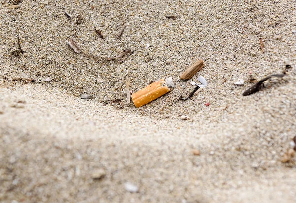 Wegwerfen von Zigarettenkippen am Strand, Sand ist nicht gut, weicher Fokus, verschwommen. — Stockfoto