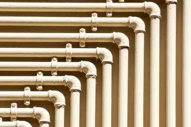 Tuğla duvarda sarı borular olan doğal gaz sayaçları.