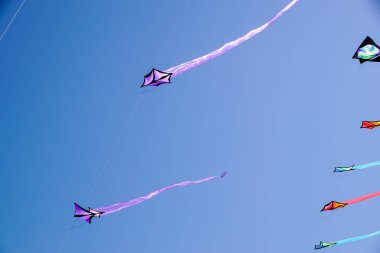 masmavi bir gökyüzü güneş ışığı ile kırmızı yay sallayarak ile renkli bir uçurtma görüş açısı