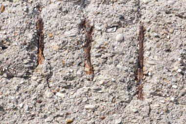 Beton yüzeyde pas lekeleri. Arka plan için eski gri beton duvar dokusu. Hasarlı ve paslı metalik takviyeli betonarme