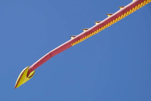 A multicolored kite flying against a blue sky — Stock Photo, Image