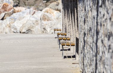 Beton zemin ve beton duvarlı bir odada ahşap bir bank.