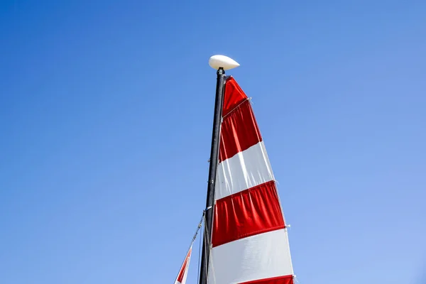 Vitorlas hajo a piros hajóznak, strandon — Stock Fotó