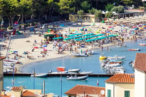 Spiaggia della Costa Azzurra con i turisti con lettini e ombrelloni nella calda giornata estiva — Foto Stock