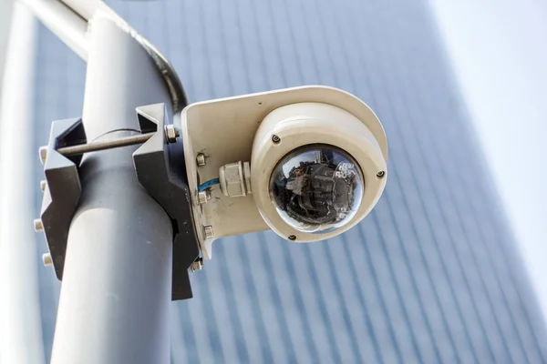 Система видеонаблюдения, охраняющая офисное здание синего небоскреба с небом над головой Стоковое Изображение