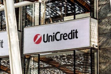 Milan, Italy - November 25, 2018: logo of the Unicredit bank, metal sign attached above the bank entrance in Milan downtown. clipart