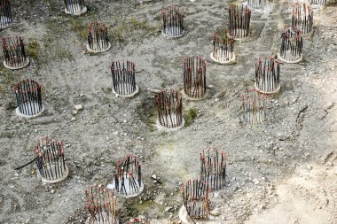 İnşaat alanında beton döşeme için takviye metal iskeleti yapan işçiler