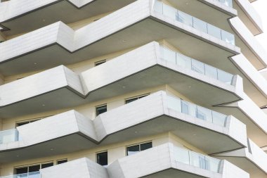 Güneşli bir günde mavi gökyüzü olan modern apartman balkon binaları. Modern bir apartmanın cephesi