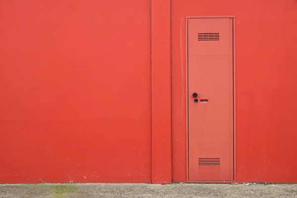 Textura de parede de concreto de cimento com porta vermelha moderna . — Fotografia de Stock