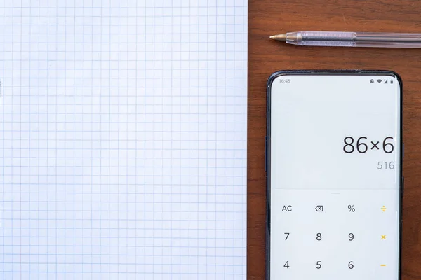 Geruit Notitieboekje Een Houten Tafel Met Pen Telefoon Met Rekenmachine — Stockfoto