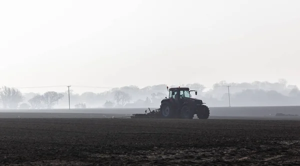 Трактор вспахивает землю — стоковое фото