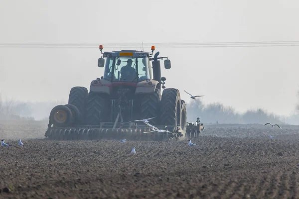 Traktör toprağı sürüyor.