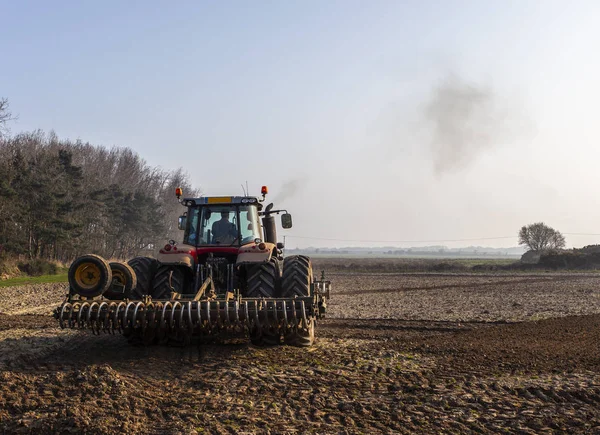 Traktör toprağı sürüyor.