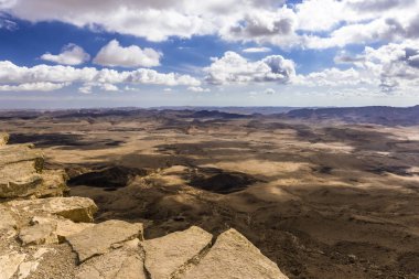 Rocky Dağları ile sarp yamaçlar Negev Çölü'nde düz kayalık bir düz parlak güneş ışınları tarafından aydınlatılmış.