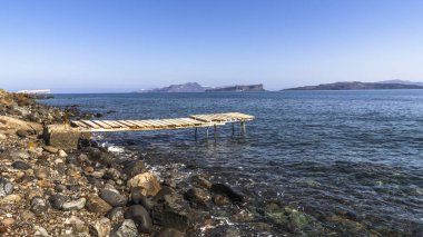Santorini Adası üzerinde kayalık Akdeniz sahilinde eski dalgalı footway.