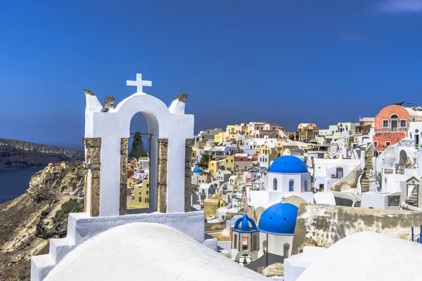 Oia Santorini Adası üzerinde sokaklarında Yunan Ortodoks Kilisesi'nin küçük çan kulesi sağda yukarıda Ege Denizi sularının derin bir uçurumun kenarında duruyor.