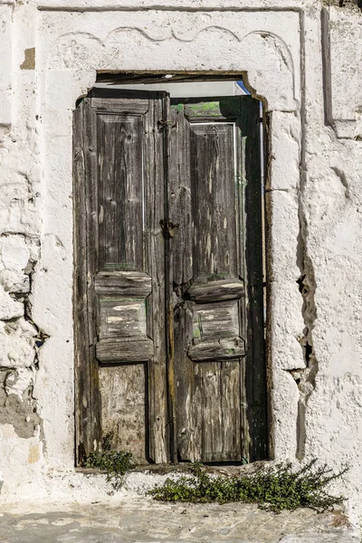 小さなギリシャの都市の狭い通りの小さな古い平屋建て家に古い木製のドア — ストック写真