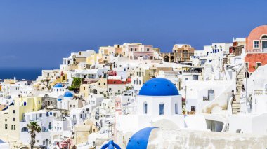 Santorini Adası üzerinde Oia şehir manzara parlak noktalar ile küçük taş evlerin renkli çatılar canlandırmak.