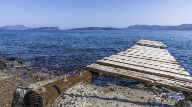 Santorini Adası üzerinde kayalık Akdeniz sahilinde eski dalgalı footway.