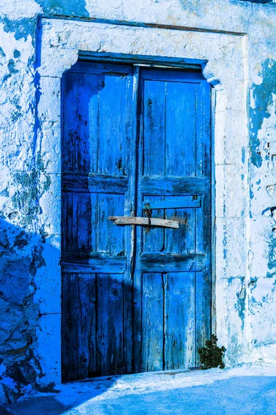 山間の小さな村の狭い道に小さなギリシャの家の明るい青いドア — ストック写真