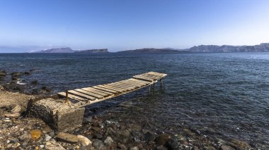Santorini Adası üzerinde kayalık Akdeniz sahilinde eski dalgalı footway.