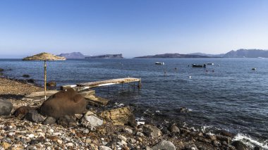 Santorini Adası üzerinde kayalık Akdeniz sahilinde eski dalgalı footway.
