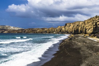 Akdeniz denizin dalgaları Santorini Adası ıssız bir kumsalda siyah kum üzerinde inanılmaz resimleri boya.
