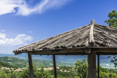 Yeşil dağların Yunanistan orta kısmında arka plan üzerinde eski bir ahşap çardak çatısı.