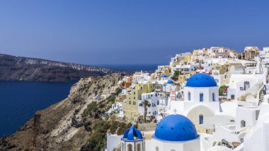 Mavi kubbeleri Ortodoks kiliseleri arasında Oia Santorini Adası üzerinde renkli evlerde