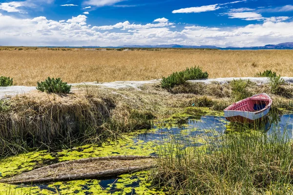 Dar bir kanal taş'a Titicaca Gölü yol olan pier bağlı birkaç balıkçı tekneleri.