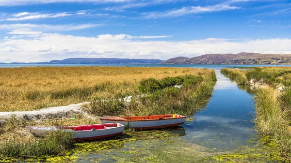 Dar bir kanal taş'a Titicaca Gölü yol olan pier bağlı birkaç balıkçı tekneleri.