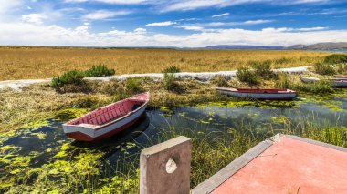 Dar bir kanal taş'a Titicaca Gölü yol olan pier bağlı birkaç balıkçı tekneleri.
