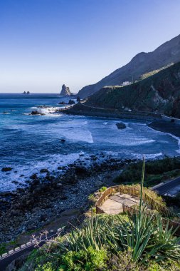 Yükselen güneşin ilk ışınları Tenerife adasının kuzey kıyısında kayalık koyları aydınlatmak.