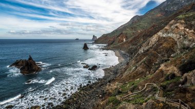 Yükselen güneşin ilk ışınları Tenerife adasının kuzey kıyısında kayalık koyları aydınlatmak.