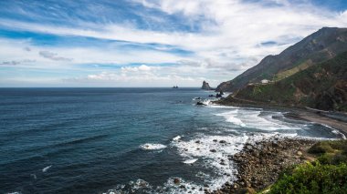 Yükselen güneşin ilk ışınları Tenerife adasının kuzey kıyısında kayalık koyları aydınlatmak.