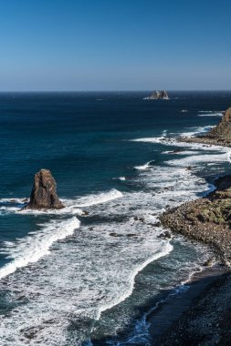 Yükselen güneşin ilk ışınları Tenerife adasının kuzey kıyısında kayalık koyları aydınlatmak.